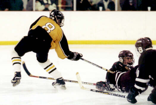 Kyle Barden gets the puck past two diving defensemen.