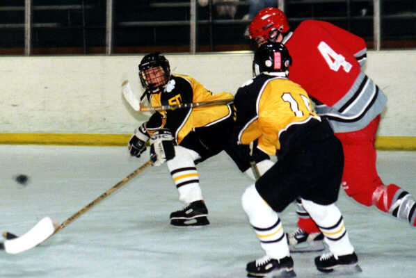 Jeremy Holmes and Pat Collins chase a loose puck against Mentor.